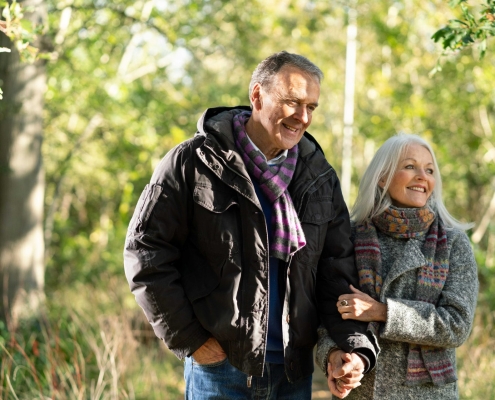 smiling couple walking in woodland