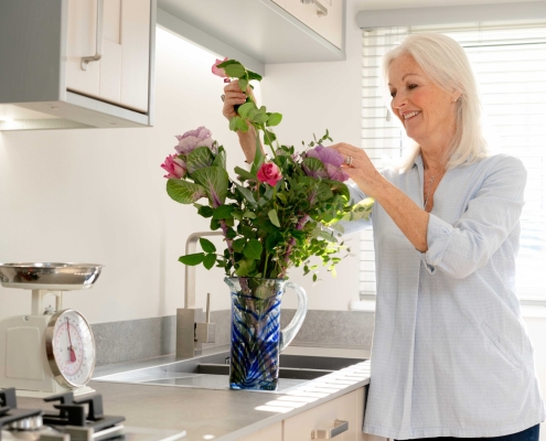 lady arranging flowers inside park home