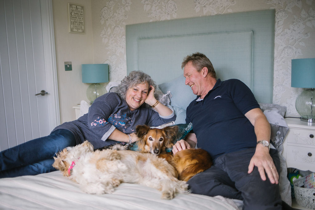 Couple laying on bed with dogs
